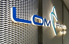 Modré světelné 3D logo LOM Praha Trade, montáž na tahokov