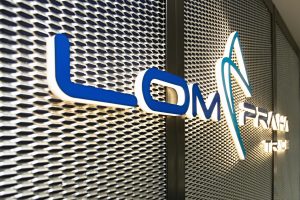 Modré světelné 3D logo LOM Praha Trade, montáž na tahokov