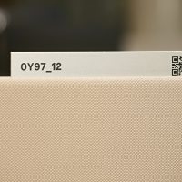 Hliníkový štítek s označením pracovního místa, černý nápise a QR kód, paravan z béžové textilie
