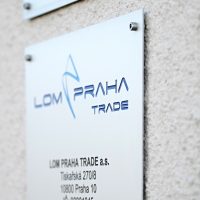 Informační cedule s logem Lom Praha Trade a adresou, gravírovaný text