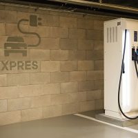 Nabíjecí stanice Siemens v podzemí garáži, piktogram dobíjení automobilu s nápisem EXPRES na stěně