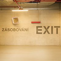 Navigace zásobování a exit na stěně garáže, malovaná grafika, čtvercové dopravní zrcadlo na stěně