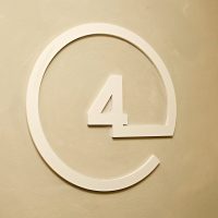 Bílá 3D číslice 4 v kružnici na stěně jako označení čtvrtého patra