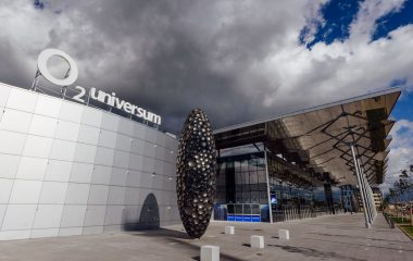 Piazzetta před budovou O2 Universum se světelným 3D logem na střeše