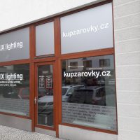 Výloha ALUX ligthing polepená pískovou folií s bílými nápisy, vyřezané texty na skleněných tabulích mezi dřevěnými rámy